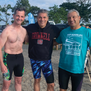 Three male swimmers celebrate and smile completion of Westport Weston YMCA 44th Point to Point at Compo Beach, Westport, CT.